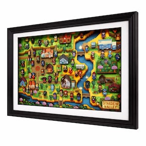 May include: Framed artwork featuring a detailed, colorful map of Stardew Valley. The map includes pixelated characters, buildings, a river, and trees. The artwork is encased in a black frame with a white mat, creating a 3D effect.