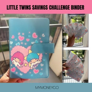 May include: A light blue savings challenge binder featuring a graphic of two cartoon characters with pink and blue hair inside a heart shape, surrounded by small hearts and stars. The set includes several matching printed cards for tracking savings.