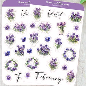 May include: Two identical sticker sheets featuring watercolor illustrations of purple violet flowers. The sheets include the text three wildflowers, February Violets, Violet, and February. The designs show various violet bouquets, wreaths, and single blossoms.