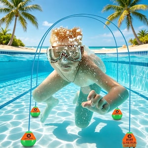 Può includere: Una persona con occhiali da sub nuota sott'acqua in una piscina, con tre giocattoli subacquei verdi e arancioni sospesi da corde blu. I giocattoli hanno la lettera "B". Palme e cielo blu sullo sfondo.