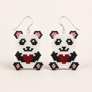 May include: A pair of beaded dangle earrings featuring a panda design. Each panda is crafted from white, black, and pink beads, holding a dark red heart in its center. The earrings are suspended from silver-toned metal fishhook ear wires.