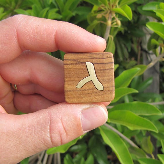 A hand-carved olive wood letter cube with brass inlay in Aramaic/Hebrew script — genuinely one-of-a-kind desk art that looks like it belongs in a museum gift shop.