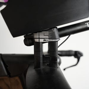 Pu&ograve; includere: Un attacco manubrio per bicicletta nero con un design grafico bianco e la scritta FOURIERS stampata sul lato. Il componente presenta due supporti cilindrici verticali che collegano il manubrio al telaio principale della bicicletta.