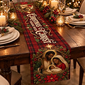 May include: A red and black plaid table runner featuring the text "CHRISTMAS BEGINS WITH CHRIST" in gold lettering, decorated with holly, poinsettias, and an illustration of the Nativity scene with Mary, Joseph, and the infant Jesus.