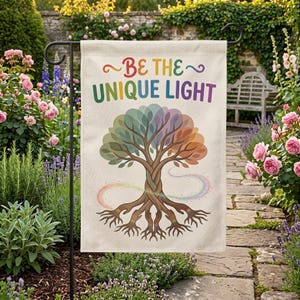 May include: A rectangular garden flag featuring a cream background with the text BE THE UNIQUE LIGHT in multicolored letters. Below the text is a tree illustration with a braided trunk and roots that transition into human hands.
