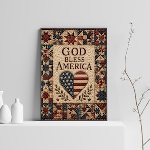 May include: A rectangular wall art print featuring a quilt-patterned border in red, white, and blue. The center displays the text GOD BLESS AMERICA above a heart-shaped graphic filled with the American flag design and two green leafy branches.