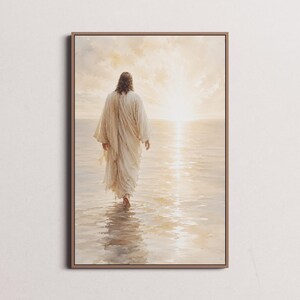 May include: A framed art print depicts a figure in a white robe walking in water towards a bright light. The artwork has a soft, warm color palette with a focus on light and reflection, creating a serene and spiritual atmosphere.