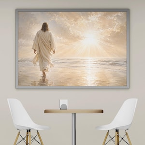 May include: Framed artwork depicting a figure in flowing white robes walking on a beach towards a bright, radiant sun. The scene is set against a backdrop of a cloudy sky and ocean waves, creating a serene and spiritual ambiance.