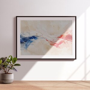 May include: A framed abstract wall art print featuring a horizontal composition with fluid watercolour-style washes in deep blue on the left and vibrant red on the right, set against a soft beige background with subtle paint splatters.