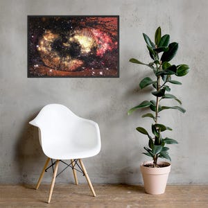 May include: A rectangular framed wall art print featuring a high-contrast, detailed close-up of a human eye iris, where the iris pattern is replaced by a vibrant, colorful nebula of deep reds, oranges, and blacks with scattered white stars.
