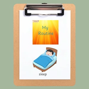 May include: A white card on a brown clipboard featuring the text My Routine and an illustration of a person sleeping in a bed with a blue blanket. The top of the card displays the text BEDTIME ROUTINE CARDS - BOY ILLUSTRATIONS and a logo.