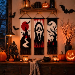 May include: Three rectangular macrame wall hangings featuring Halloween imagery. The left piece shows a red moon and black castle, the center piece depicts a white ghost mask on a black background, and the right piece displays a white moon and tree.