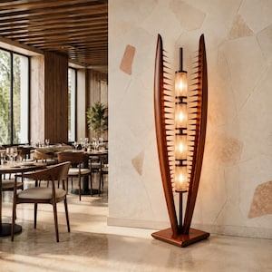 Peut inclure: Un lampadaire haut doté d'un cadre en bois foncé avec deux panneaux latéraux incurvés et pointus entourant une colonne centrale verticale. La colonne supporte quatre luminaires cylindriques en verre empilés diffusant une lumière chaude.