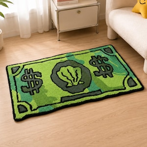 Può includere: Un tappeto trapuntato rettangolare caratterizzato da un design verde brillante ispirato a una banconota. Il tappeto presenta simboli del dollaro verde scuro sui lati sinistro e destro, con un emblema circolare centrale con una conchiglia.