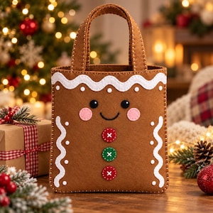 Pode incluir: Uma bolsa de feltro castanha em forma de boneco de gengibre, com um rebordo de glacê branco ondulado, dois olhos pretos, um sorriso preto, duas bochechas cor-de-rosa e três botões circulares em vermelho, verde e vermelho, cosidos com fio branco.