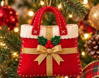 May include: A red felt handbag ornament featuring a white top trim, gold ribbon with a central bow, and green holly leaves with three red berries. The bag has two red handles and is stitched with white thread along the edges for hanging.