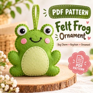 May include: A green felt frog ornament with a light green belly, pink cheeks, and black eyes. A green ribbon loop is attached to the top. Text reads: PDF PATTERN, Felt Frog Ornament, Bag Charm, Keychain, Ornament, PDF PATTERN.