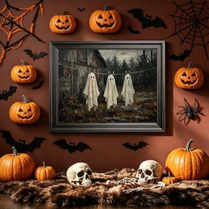 May include: A framed painting of three ghost-like figures hanging on a clothesline in front of a rustic barn, surrounded by orange jack-o'-lanterns, black paper bats, spider webs, and two human skulls resting on a brown faux fur rug.