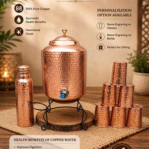 Puede incluir: Un juego de dispensador de agua de cobre que incluye un recipiente grande de cobre martillado con tapa y grifo sobre un soporte de metal negro, una botella de cobre a juego y seis vasos de cobre martillado. Texto: COPPER WATER DISPENSER SET.