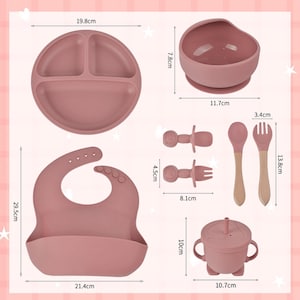 May include: A set of baby feeding essentials in a dusty rose color. Includes a divided plate (19.8 cm), a suction bowl (11.7 cm), a bib (21.4 cm), a sippy cup (10.7 cm), two teethers (8.1 cm), and a spoon and fork (13.8 cm).