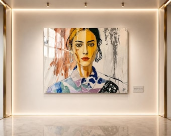 May include: A large, rectangular painting of a woman's face, with a colorful collared shirt. The artwork features a split face, with one side in warm tones and the other in cool tones. The painting is displayed on a white wall.