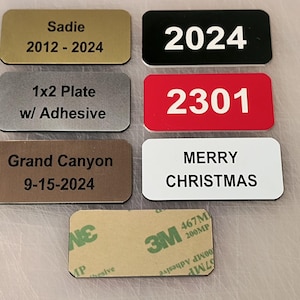 May include: A collection of six rectangular name tags with black text on various colored backgrounds. The tags include the text "Sadie 2012-2024", "2024", "1x2 Plate w/ Adhesive", "2301", "Grand Canyon 9-15-2024", and "MERRY CHRISTMAS".