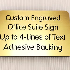 May include: Gold-colored metal office suite sign with black engraved text that reads "Custom Engraved Office Suite Sign Up to 4-Lines of Text Adhesive Backing".