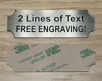 May include: A silver metal plaque with rounded corners and a brushed finish. The plaque has two lines of text that read "2 Lines of Text" and "FREE ENGRAVING!" The plaque has a 3M adhesive backing.