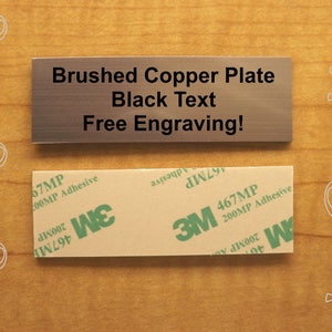 May include: A brushed copper plate with black text that reads "Brushed Copper Plate Black Text Free Engraving!" The plate has a protective adhesive backing.