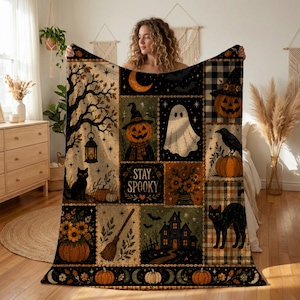 May include: A rectangular throw blanket featuring a patchwork design with Halloween motifs including a ghost, jack-o'-lanterns, black cats, a haunted house, a broom, and sunflowers. The center panel displays the text Stay Spooky in a decorative font.