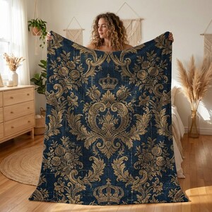 May include: A rectangular throw blanket featuring a deep navy blue background with an intricate, repeating gold damask pattern. The design includes ornate scrolling acanthus leaves, floral motifs, and prominent crown icons centered throughout.