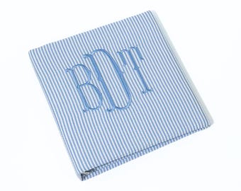 May include: A blue and white striped fabric pouch with the monogram "BDF" embroidered in blue thread.