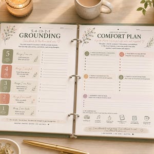 Può includere: Un raccoglitore a tre anelli aperto su due pagine che presenta un esercizio di radicamento 5-4-3-2-1 e un piano di conforto per l'ansia. Le pagine includono testo stampato, elenchi numerati e piccole illustrazioni botaniche in toni tenui.