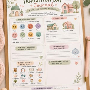 May include: A Transition Day Journal printed on paper held by a gold clipboard. The page features sections for feelings, daily activities, and affirmations, decorated with watercolor illustrations of houses, hearts, and a teddy bear.