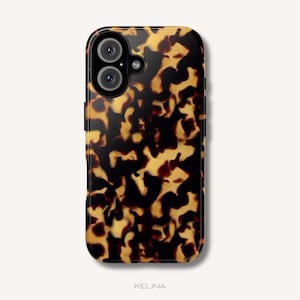 Op de afbeelding: Een rechthoekig smartphonehoesje met een glanzend schildpadpatroon in onregelmatige zwarte en amberkleurige vlekken. Het hoesje heeft een ronde uitsparing voor de camera linksboven en het woord KELINA staat onderaan gedrukt.