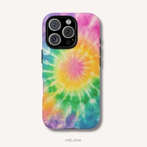 Puede incluir: Una funda para smartphone con un vibrante patrón tie-dye y un diseño central de rayos de sol en tonos rosa, amarillo, verde y azul. La funda tiene un recorte negro para el módulo de cámara en la esquina superior y la palabra KELINA abajo.