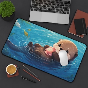 Puede incluir: Alfombrilla de ratón rectangular con una ilustración de una nutria de dibujos animados flotando en agua azul, sosteniendo una concha rosa. La nutria tiene pelaje marrón y una expresión linda. La alfombrilla está bordeada de negro.