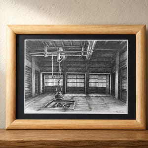 Könnte beinhalten: Eine gerahmte Schwarz-Weiß-Zeichnung eines traditionellen japanischen Interieurs. Das Kunstwerk zeigt einen Raum mit Holzbalken, Shoji-Bildschirmen und einem hängenden Kessel. Der Rahmen besteht aus hellem Holz, die Zeichnung ist auf einem schwarzen Passepartout.