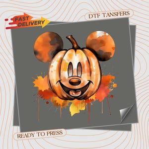 May include: A DTF transfer sheet featuring a watercolor-style illustration of a pumpkin shaped like a mouse head with round ears. The design includes orange and yellow paint splatters, a smiling face, and the text FAST DELIVERY and READY TO PRESS.