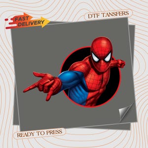 May include: A DTF transfer featuring a graphic of a red and blue superhero character in a web-shooting pose inside a black circle. The design includes the text FAST DELIVERY and DTF TANSFERS and READY TO PRESS on a gray background with a wavy line pattern.