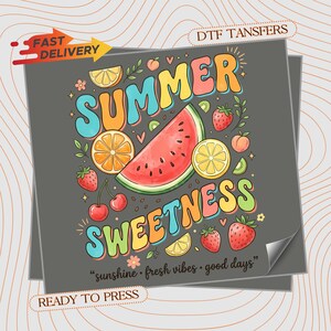 May include: A gray DTF transfer sheet featuring the text SUMMER SWEETNESS in colorful bubble letters, surrounded by illustrations of watermelon, orange slices, strawberries, cherries, and peaches, with the text sunshine fresh vibes good days.