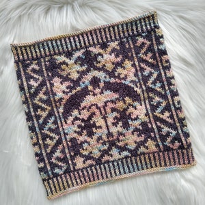May include: A square knitted cushion with a geometric pattern in shades of brown, pink, and yellow.