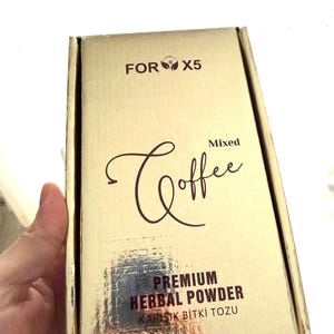 Könnte beinhalten: Eine goldfarbene Schachtel mit den Worten "FOR X5" oben. Die Schachtel hat das Wort "Coffee" in einer Schreibschrift, mit den Worten "Mixed" darüber. Auf der Unterseite der Schachtel steht "PREMIUM HERBAL POWDER".
