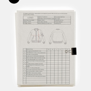 Può includere: Un documento tecnico per un bomber oversize, con specifiche di design e misure. Il documento include il logo del marchio, i dettagli dello stile e una clip nera. Il colore è antracite.