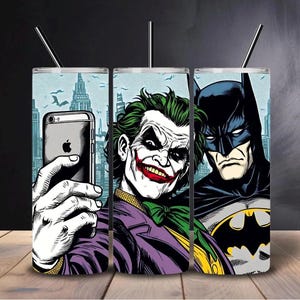 以下が含まれることがあります： 黒いストローが付いた3つのステンレス鋼タンブラー。各タンブラーには、バットマン、ジョーカー、ジョーカーとの自撮り写真の漫画スタイルのイラストが描かれています。背景には街並みが描かれています。