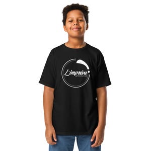 Puede incluir: Camiseta negra con un diseño circular blanco con el texto "L'imprévi" e "Improvisation". La camiseta está hecha de un material suave y la lleva una persona.