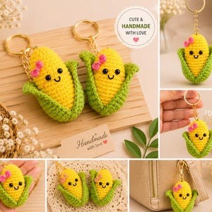 May include: A crochet corn keychain featuring a bright yellow cob with a smiling face, black eyes, and a small pink bow. The corn is wrapped in green husks and attached to a gold-toned metal keyring. The design is compact and textured.