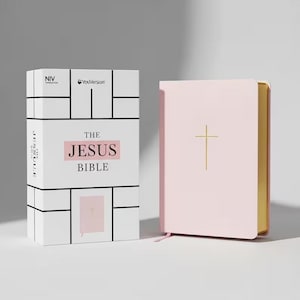 Puede incluir: Una Biblia rosa con una cruz dorada y páginas doradas. El libro está junto a una caja blanca con el texto "THE JESUS BIBLE" en rosa y los logotipos "NIV" y "YouVersion".