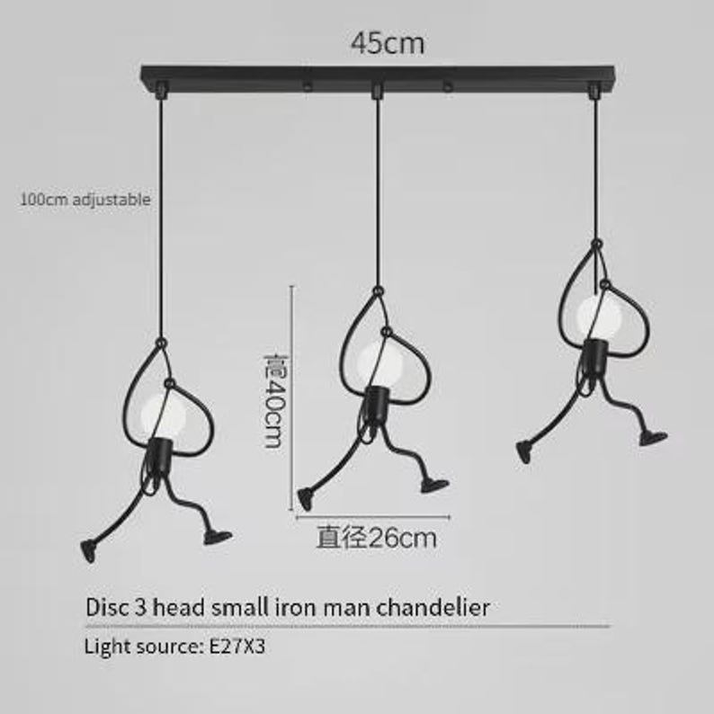 K&ouml;nnte beinhalten: Schwarze Eisenmann-Pendelleuchte mit drei Lichtern. Die Leuchte ist 45 cm breit, mit verstellbaren Kabeln bis zu 100 cm. Jedes Licht hat einen Durchmesser von 26 cm und ist 40 cm hoch. Der Text lautet "Disc 3 head small iron man chandelier".