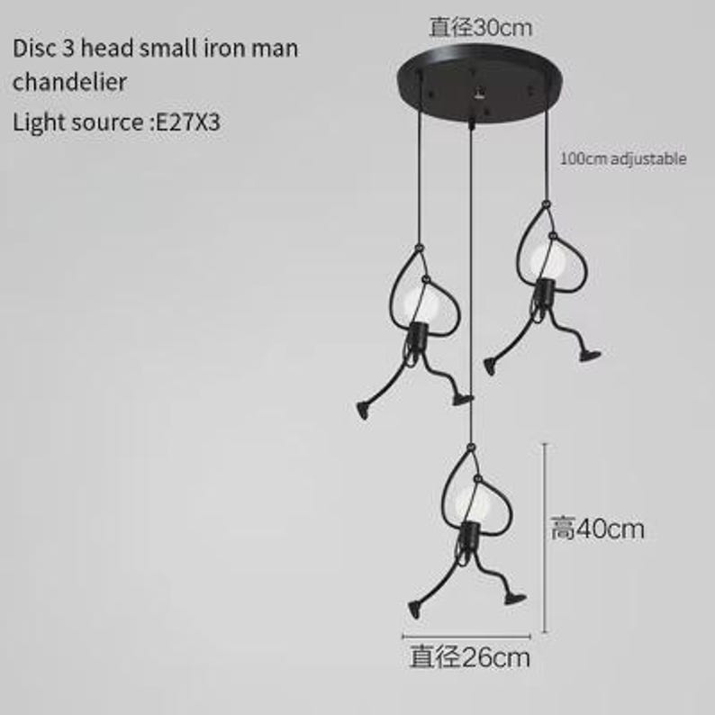 K&ouml;nnte beinhalten: Schwarze Eisenmann-H&auml;ngeleuchte mit drei Lichtern. Die Leuchte hat eine Deckenplatte mit 30 cm Durchmesser und verstellbare Kabel. Jede Leuchte hat eine stilisierte Figur mit einer Gl&uuml;hbirne. Die Gesamth&ouml;he betr&auml;gt 40 cm.